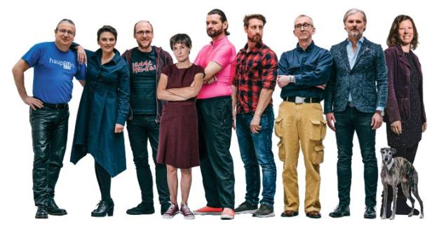 Eine Gruppe von neun Personen und ein Windhund stehen nebeneinander.