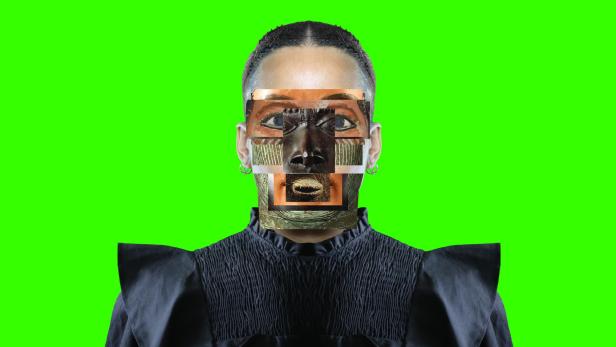 Eine Person mit einem Gesicht, das aus Fragmenten einer antiken Statue zusammengesetzt ist, vor einem grünen Hintergrund.