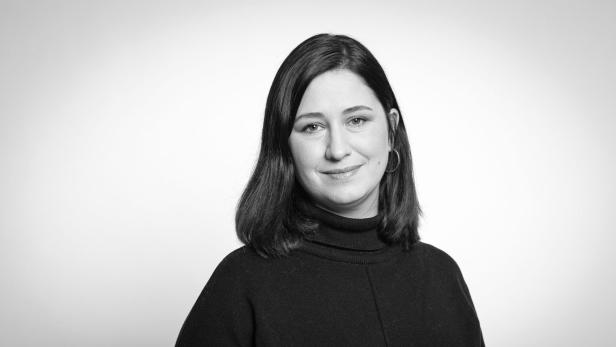 Porträt einer Frau mit dunklen Haaren und einem schwarzen Rollkragenpullover.