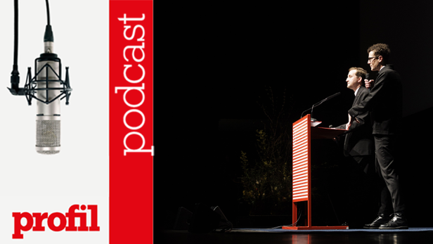 Zwei Männer stehen auf einer Bühne an einem Rednerpult, im Hintergrund das Logo des „Profil“-Podcasts.