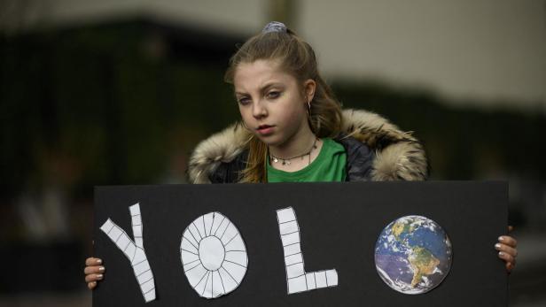 Ein Mädchen hält während eines Jugend-Klimastreiks vor dem New Yorker Hauptquartier der Vereinten Nationen ein Schild mit der Aufschrift „YOLO“ (Man lebt nur einmal).