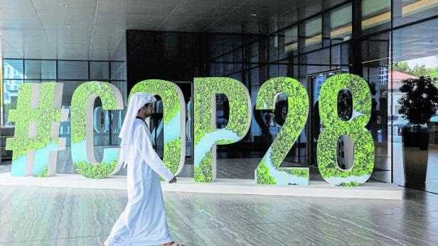 FILE PHOTO: A person walks past a "#COP28" sign during The Changemaker Majlis, a one-day CEO-level thought leadership workshop focused on climate action, in Abu Dhabi