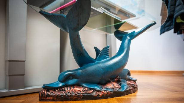 Der Delfintisch im Klimaministerium. Zwei Delfine aus Bronze halten mit Flossen Glasplatte.