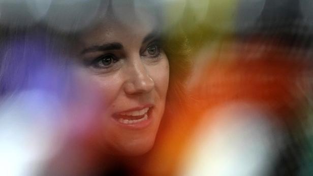 Das Gesicht einer Frau mit hellen Augen und leicht geöffnetem Mund.