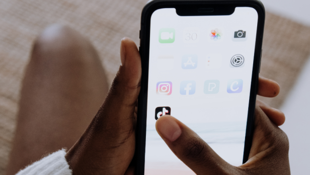 Eine Person tippt auf dem Bildschirm eines Smartphones mit Social-Media-Apps.