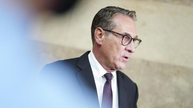 Ein Mann mit Brille und Anzug spricht.