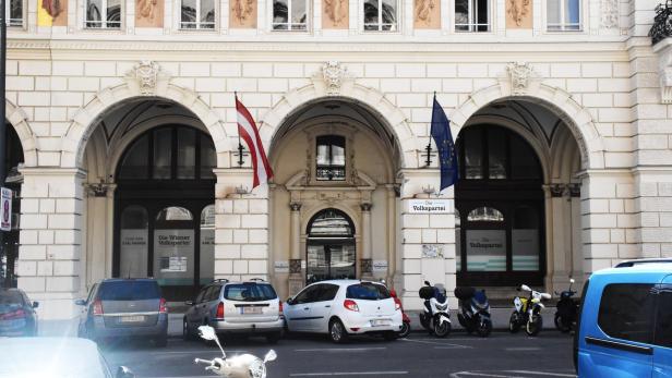 Das Gebäude der Wiener Volkspartei mit geparkten Autos und Motorrollern davor.