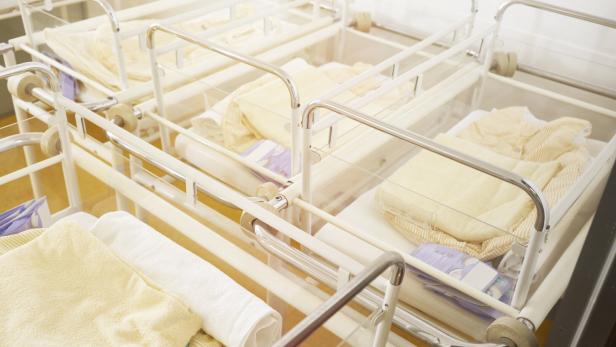 Mehrere leere Babybetten in einem Krankenhauszimmer.