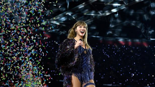 Taylor Swift tritt auf der Bühne vor fallendem Konfetti auf.