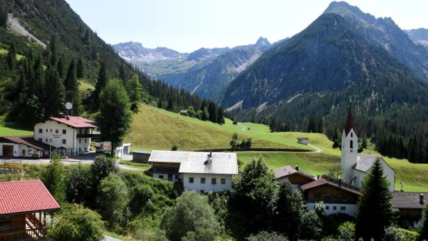 Ein Panoramablick auf die Gemeinde Gramais, zu sehen sind die Kirche, das Gemeindeamt und die umliegenden Berge 