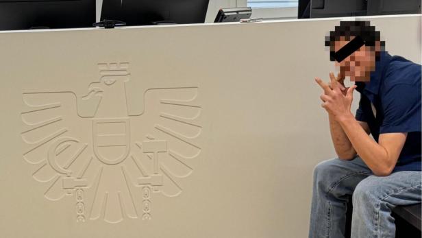 Junger Bursche sitzt auf Angklagebank vor Gericht und hebt drei Finger hoch, den Serbengruß.