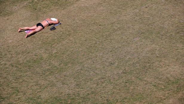 person mit sonnenbrand auf trockenem gras