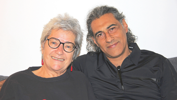 Ruti Katz und Osama Zater sitzen lächelnd auf einer Couch