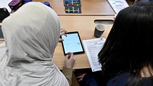 Man sieht zwei Schülerinnen, eine trägt Kopftuch