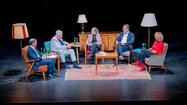 Die dritte Veranstaltung von "Unbequeme Wahrheiten" am 17. September befasste sich mit der Beziehung zwischen profil und der FPÖ. Vom links nach rechts:Gernot Bauer, Andreas Mölzer, Anna Thalhammer, Heinz Christian Strache und Eva Linsinger sitzen auf der Bühne des Theater Akzent. Um sie herum sind Stehlampen plaziert. Der Hintergrund ist dunkel. Am Fuße der Bühne sind die Köpfe der Zuschauer auszumachen.