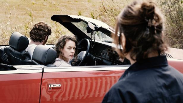 Gestrandet in einer Ersatzfamilie: Paula Beer in Christian Petzolds neuem Film "Miroir No. 3" Junge Frau in rotem Auto blickt vom Beifahrersitz aus auf eine andere Frau im Vordergrund