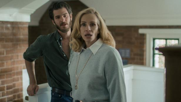 Andrew Garfield und Julia Roberts in "After the Hunt" Blonde Frau mit schockiertem Gesicht, hinter ihr ein erstaunt blickender jüngerer Mann