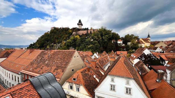 Der private Mietmarkt in Graz wirbt mit besonderen Mietpreis-Zuckerln Die Dächer von Graz und der Uhrturm am Schlossberg. Der Himmel ist bewölkt.