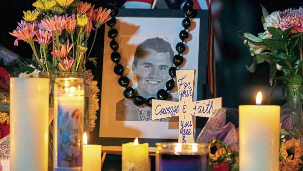 Candles and flowers are seen near a portrait of right-wing activist Charlie Kirk at a makeshift memorial during a candlelight vigil at Memorial Park in Provo, Utah,