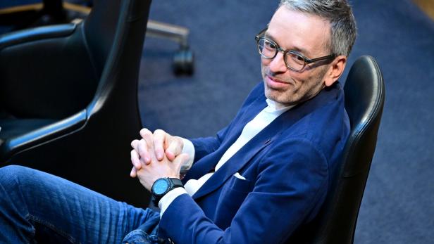 Ein Mann mit Brille und blauer Jacke, FPÖ-Obmann Kickl, sitzt entspannt auf einem Stuhl und verschränkt die Hände.