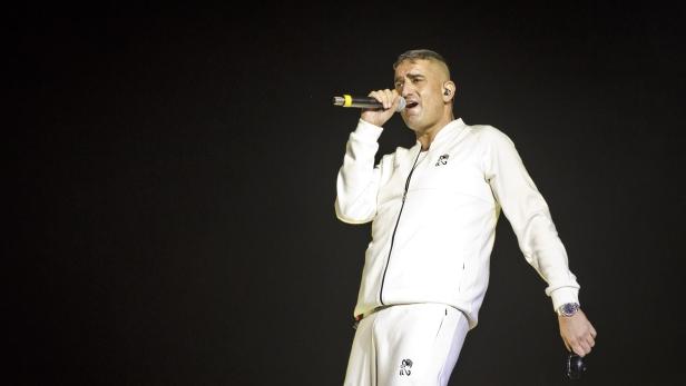 Rapper Haftbefehl im weißen Jogginganzug auf der Bühne