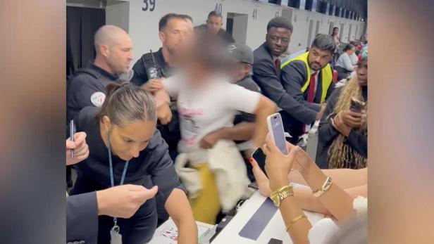 Eine schreiende Frau muss am Pariser Flughafen von der Security abgeführt werden.