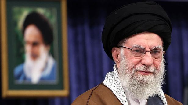 Irans oberster Führer Ayatollah Ali Khamenei steht vor einem Bild von Ruhollah Chomeini.