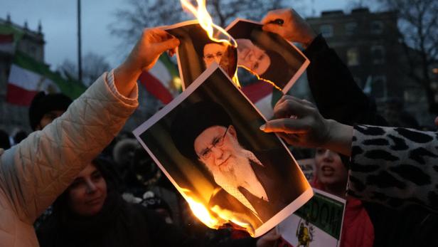 Menschen verbrennen Fotos des Obersten Führers des Iran, Khamenei