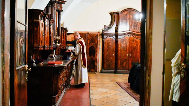 Ein Priester steht vor der Sakristei in der Wiener Paulanerkirche