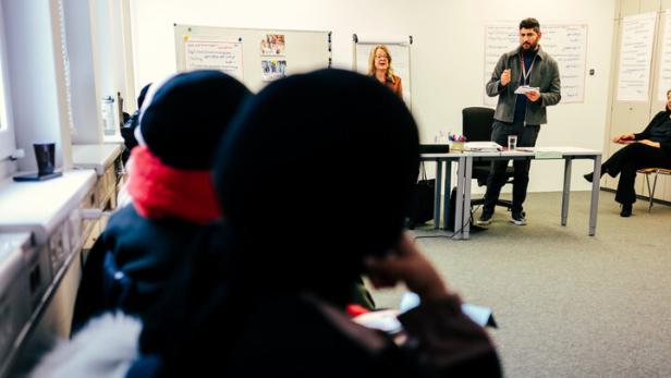 Frauen mit Kopftuch sitzen im Klassenzimmer
