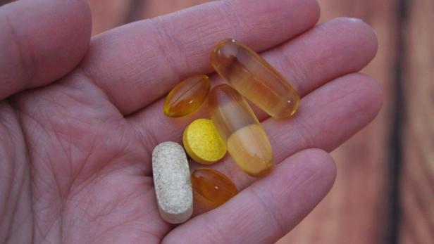 Person, die Medikamententabletten in der Hand hält