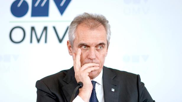 Rainer Seele sitzt nachdenklich vor einem OMV-Logo, während über seine mögliche Rückkehr in den OMV-Aufsichtsrat spekuliert wird.