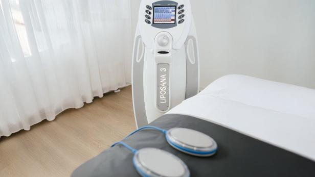 Detox-Gerät LIPOSANA 3 und Behandlungsliege in einem hellen Studio.