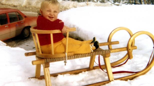 Hermann Maier als Einjähriger auf Schlitten im Schnee