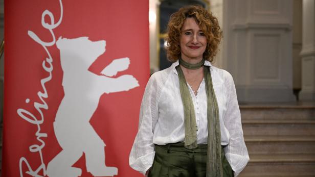 Berlinale-Chefin Tricia Tuttle posiert neben dem Bären-Logo ihres Festivals