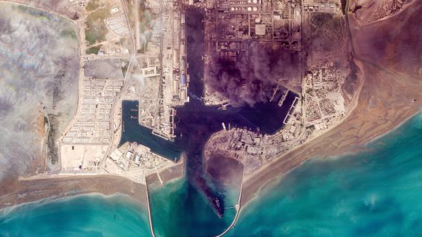 Ein Satellitenbild der saudischen Öl-Raffinerie Ras Tanrua. Schwarze Rauchschwaden steigen von der Anlage auf.