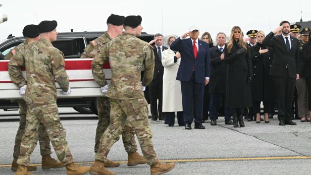 Soldaten tragen einen Sarg, im Hintergrund die US-Regierung