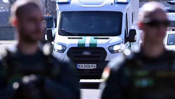 Ein konfiszierter Geldtransporter, im Vordergrund zwei uniformierte Männer. 