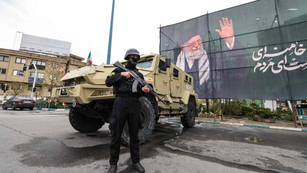 Ein vermummter Bewaffneter vor einem Militärjeep