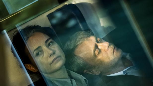 Das Schauspielduo Özgü Namal und Tansu Biçer mit ernsten Gesichtern hinter Fensterglas