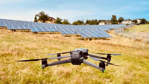 Eine Drohne fliegt über PV-Anlagen 