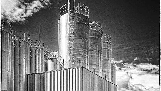 Ein schwarz-weiß Bild von Silo-Lagerstationen einer Industriestätte.