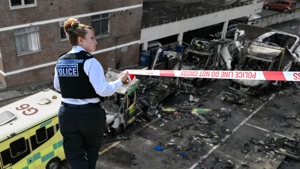 Fotocollage: Eine Polizistin mit Absperrband, dahinter vier zerstörte Krankenwägen.