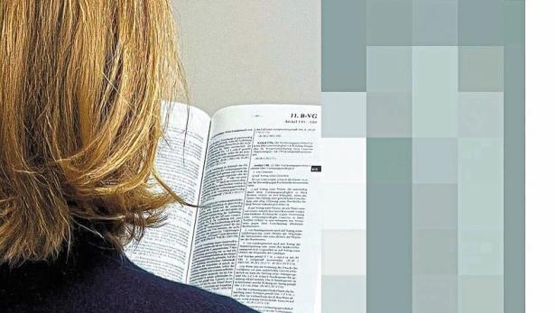 Eine junge Frau liest in einem juristischen Fachbuch, symbolisch für die Herausforderungen junger Akademikerinnen durch den Einsatz von KI im Rechtsbereich.