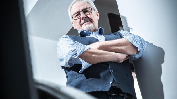 Ein Mann mit Brille und verschränkten Armen, es ist der ORF-Manager Pius Strobl,  steht an einem Treppengeländer.