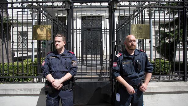 Zwei Polizisten stehen vor dem Gatter der russischen Botschaft in Wien.