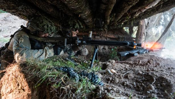 Soldaten schießen mit einem Maschinengewehr