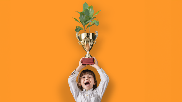 Kind hält Pokal mit Pflanze, auf orangem Grund