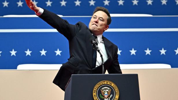 Elon Musk reckt die rechts Hand wie zum Hitlergruß