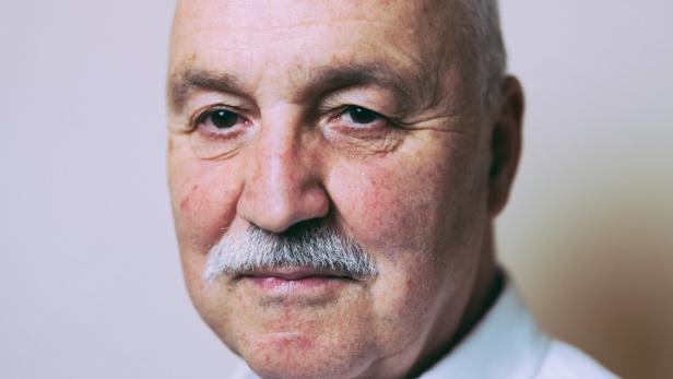 Porträt des Theologen Wolfgang Palaver vor neutralem, grau-weißem Hintergrund 